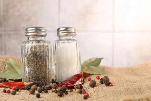Çuval bezinde baharat bulunan tuzluk ve biberlikler arka planda bulanık, yakın plan. Metin için boşluk