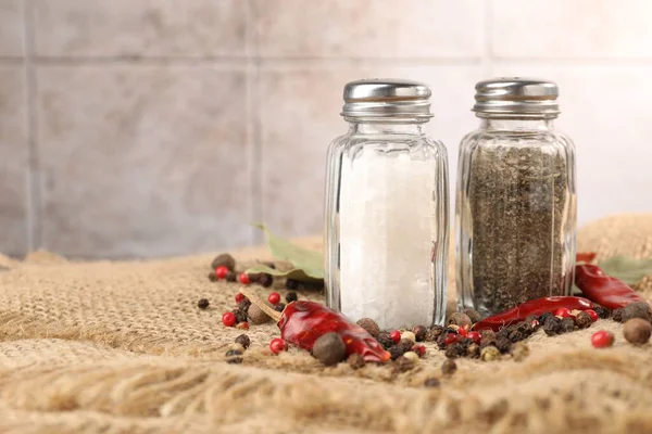 Çuval bezinde baharat bulunan tuzluk ve biberlikler arka planda bulanık, yakın plan. Metin için boşluk