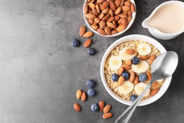 Yabanmersinli yulaf gevreği, muz, badem sütü ve fındıklar gri masada, düz yatıyordu. Metin için boşluk