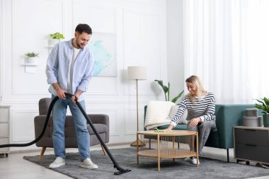 Birlikte oturma odasını toplayan bir çift. Ev işleri.