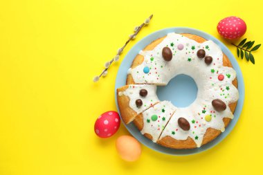 Lezzetli Paskalya pastası, boyanmış yumurtalar, söğüt dalı ve sarı arka planda yapraklar, düz uzanma. Metin için boşluk