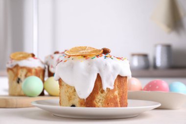 Lezzetli paskalya pastaları ve boyalı yumurtalar mutfaktaki ışık masasında, yakın plan.