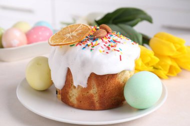 Lezzetli Paskalya pastası, boyanmış yumurta ve laleler ışık masasında, yakın plan.