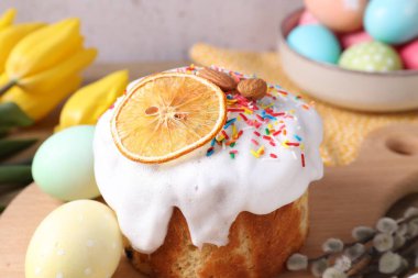 Lezzetli Paskalya pastası, boyanmış yumurtalar, söğüt dalları ve masada laleler, yakın plan.