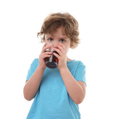 Küçük çocuk beyaz arka planda taze nar suyu içiyor.