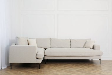 Oturma odasındaki beyaz duvarın yanındaki rahat kanepe.