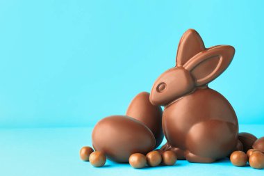 Çikolatalı Paskalya tavşanı ve açık mavi arka planda yumurtalar. Metin için boşluk
