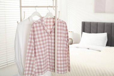 İçerideki yatağın yanındaki askıda asılı duran şık pijama gömlekler, metin için yer