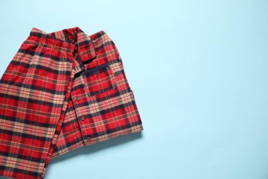 Açık mavi arka planda şık pijamalar, üst manzara. Metin için boşluk