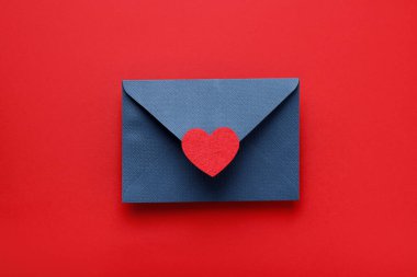 Sevgililer Günün kutlu olsun. Tebrik kartı ve kırmızı arka planda dekoratif kalp ile zarf, üst görünüm