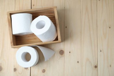 Tahta masadaki sandıkta tuvalet kağıdı ruloları. Metin için boşluk