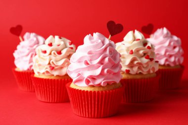 Sevgililer Günün kutlu olsun. Kırmızı arka planda kalpleri olan lezzetli kekler, yakın plan.