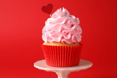 Sevgililer Günün kutlu olsun. Kırmızı arka planda kalp kaplaması olan lezzetli kek, yakın plan.