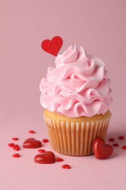 Sevgililer Günün kutlu olsun. Pembe arka planda kırmızı kalpleri olan lezzetli kek, yakın plan.