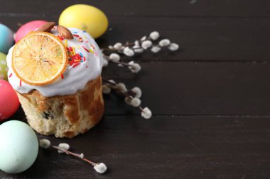 Lezzetli Paskalya pastası, boyanmış yumurtalar ve tahta masanın üzerinde söğüt dalları, yakın plan. Metin için boşluk