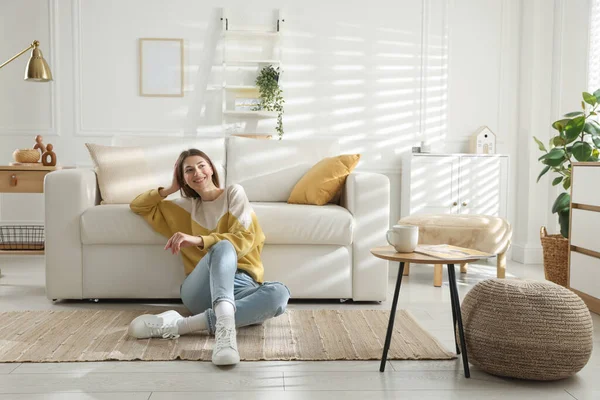 Evdeki koltuğun yanında dinlenen bir kadın.