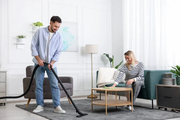 Birlikte oturma odasını toplayan bir çift. Ev işleri.