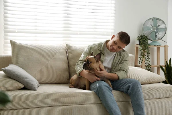 Evdeki kanepede dinlenen sevimli köpeğiyle genç bir adam, mesaj atmak için yer var.