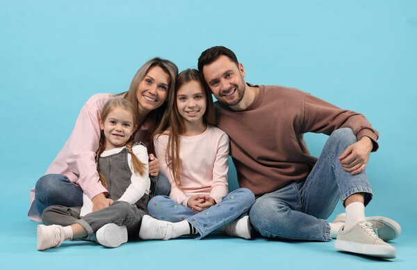 Portrait of happy family on light blue background