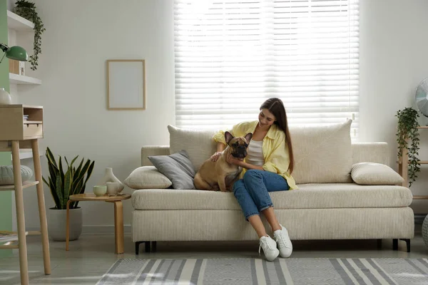 Evdeki kanepede tatlı köpeğiyle dinlenen bir kadın.