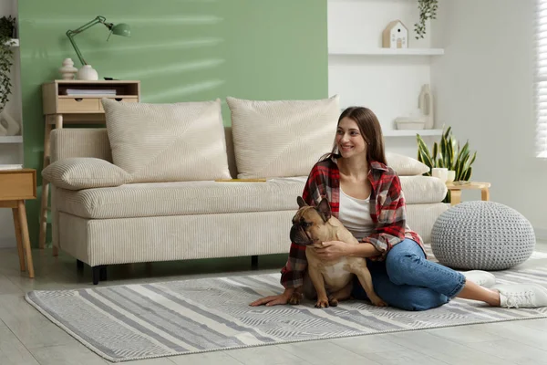 Evdeki kanepenin yanında sevimli köpeği olan bir kadın.