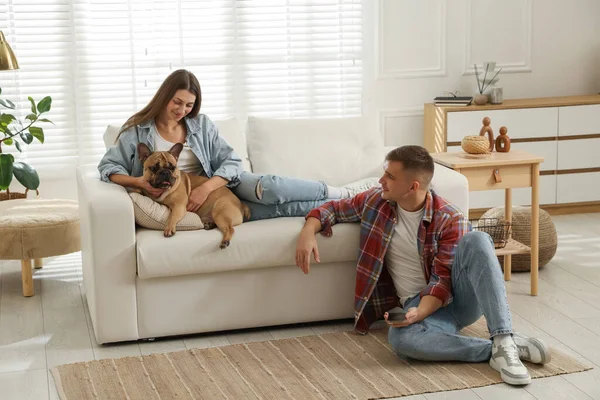 Evde dinlenen sevimli köpekli bir çift.