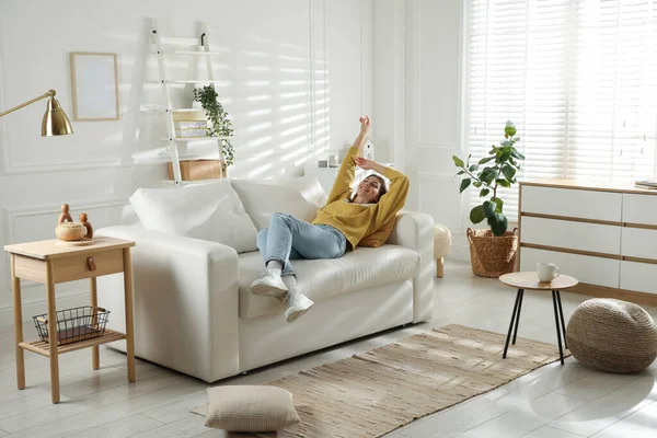 Mutlu kadın evdeki kanepede dinleniyor.