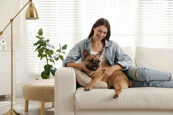 Evdeki kanepede tatlı köpeğiyle dinlenen bir kadın.