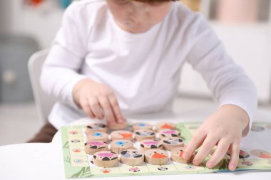 Beyaz masada oyuncaklarla oynayan sevimli küçük çocuk, yakın plan.