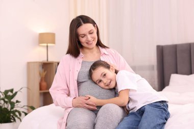 Hamile kadın ve kızı evde yatıyorlar.