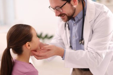 Doktor hastahanedeki randevuda küçük kızı muayene ediyor.