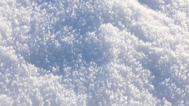 Açık havada güneşli kar, yakın çekim. Kamera sağa sola hareket ediyor