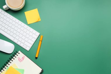 Ofis işyeri. Bilgisayar klavyesi, kahve ve kırtasiye malzemesi yeşil masada, düz yerde. Metin için boşluk