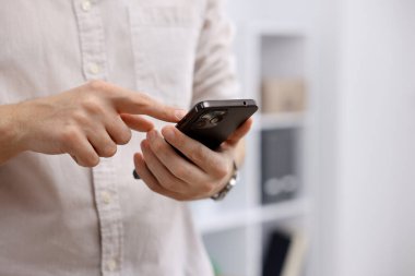 Ofiste akıllı telefon kullanan bir adam, yakın plan. Metin için boşluk