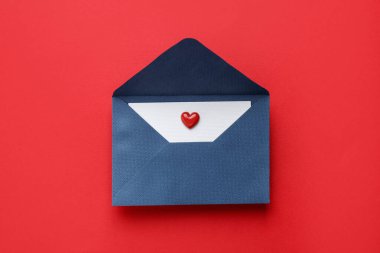 Sevgililer Günün kutlu olsun. Tebrik kartı ve kırmızı arka planda dekoratif kalp ile zarf, üst görünüm