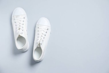 Gri arka planda bir çift şık spor ayakkabı, üst manzara. Metin için boşluk