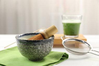 Yeşil kibriti seramik kasede, fincanda, bambu çırpıcıda ve ışık masasında süzgeçte serinletiyor.