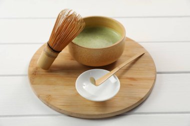 Seramik kasede taze yeşil kibrit, bambu çırpıcı ve beyaz ahşap masa kepçesi, yakın çekim