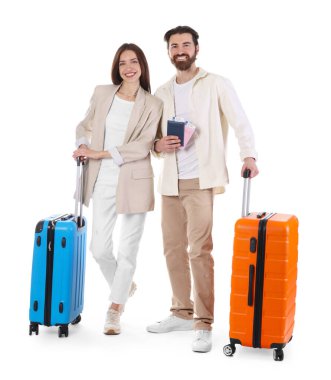 Bavulları, pasaportları ve beyaz arka planda biletleri olan mutlu çift.