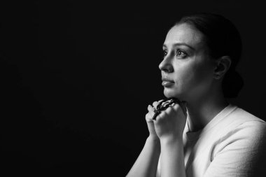 Karanlık arka planda dua eden kadın, mesaj için yer var. Siyah ve beyaz etkisi