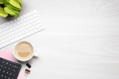 Ofis işyeri. Bilgisayar klavyesi, kahve ve kırtasiye malzemesi beyaz ahşap masada, düz yerde. Metin için boşluk