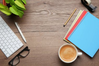 Ofis işyeri. Bilgisayar klavyesi, kahve ve kırtasiye malzemesi ahşap masada, düz yerde. Metin için boşluk