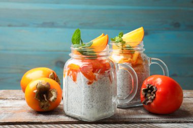 Ahşap masada servis edilen nane ve hurma kavanozlu lezzetli chia pudingi.