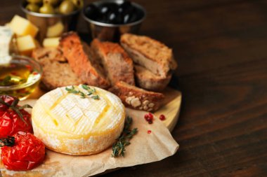 Farklı peynir türleri ve ahşap masadaki diğer atıştırmalıklar, yakın plan. Metin için boşluk