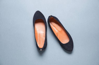 Gri arka planda bir çift şık siyah ayakkabı.