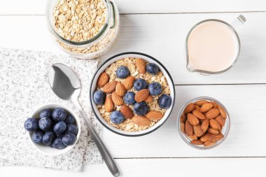 Yulaf gevreği, badem sütü, yaban mersini ve fındık beyaz ahşap masa, düz yatıyordu.