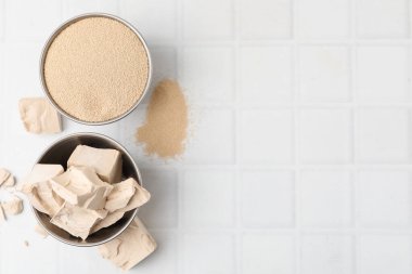 Beyaz fayanslı masada taze ve kuru maya, düz. Metin için boşluk