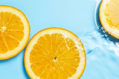 Açık mavi zemin üzerinde portakal dilimleri, düz uzanmış.