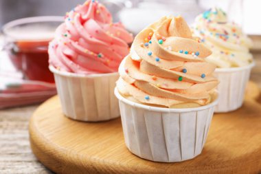 Tahta masaya serpiştirilmiş lezzetli kekler ve çay, yakın plan.