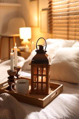 Güzel bir Noel feneri, yanan mumlar ve sıcak bir bardak içecekle birlikte.